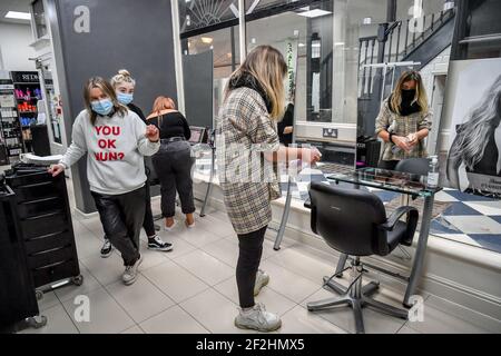 Die Mitarbeiter des Michelle Marshall Salons in Duke St Arcade, Cardiff, reinigen und desinfizieren den Salon, bevor sie ihre Kunden begrüßen, wenn Friseure und Barbiere in Wales ab Montag wieder zu Terminen geöffnet werden können. Bilddatum: Freitag, 12. März 2021. Stockfoto