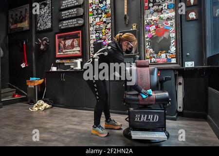 Ein Barbier in Duke St Arcade, Cardiff, wird gereinigt und desinfiziert, bevor er seine Kunden begrüßt, wenn Friseure und Barbiere in Wales ab Montag wieder zu Terminen geöffnet werden können. Bilddatum: Freitag, 12. März 2021. Stockfoto