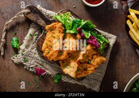 Zartes Schnitzel mit frischem Salat, Tomaten und pommes frites Stockfoto