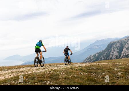 Zwei männliche Radfahrer Radfahren auf der Bergstraße Stockfoto