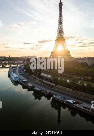 Perfekte Luftaufnahme des Goldenen Sonnenaufgangs durch den Eiffelturm vom Ufer der seine aus, Paris, Frankreich. Ein Turm auf dem Champs de mars Stockfoto