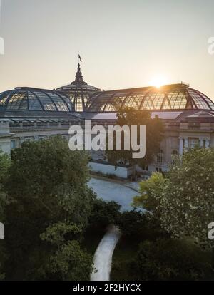 Sonnenaufgang über Glasdach und Kuppel des Grand Palais of Beaux Arts Architecture (Champs Élysées) in Paris, gekrönt von der französischen Flagge Stockfoto