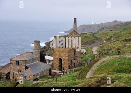 Levant Zinnmine mit seiner dampfbetriebenen Strahlmaschine auf der Klippe bei Penwith, auf der Landzunge dahinter ist der Pendeen Leuchtturm. Cornwall, England, Großbritannien Stockfoto