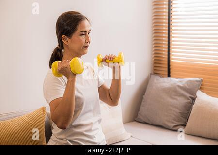 Training zu Hause. Sportliche Frau dabei Yoga-Plank während Online-Tutorial auf Laptop-Training im Wohnzimmer. Stockfoto