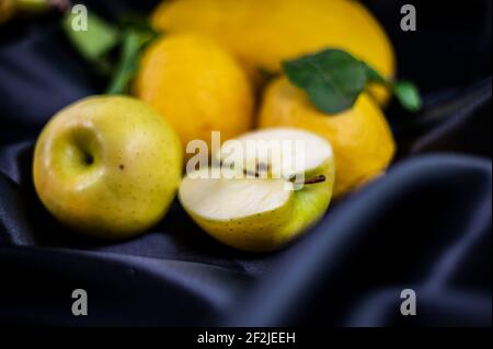 Gelbe Früchte auf schwarzem Hintergrund mit Melone Bananen Äpfel Und Zitronen Stockfoto