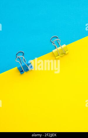 Binder wird auf einem blauen und gelben Papierhintergrund befestigt Stockfoto