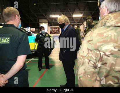 Premierminister Boris Johnson trifft sich mit Mitgliedern des nordirischen Rettungsdienstes und Militärmedizinern während eines Besuchs der Flugstation des Joint Helicopter Command in Aldergrove in Nordirland. Bilddatum: Freitag, 12. März 2021. Stockfoto