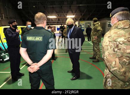 Premierminister Boris Johnson trifft sich mit Mitgliedern des nordirischen Rettungsdienstes und Militärmedizinern während eines Besuchs der Flugstation des Joint Helicopter Command in Aldergrove in Nordirland. Bilddatum: Freitag, 12. März 2021. Stockfoto