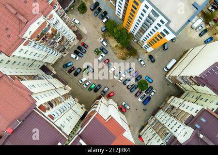 Luftaufnahme von geparkten Autos auf dem Parkplatz zwischen hohen Wohngebäuden. Stockfoto