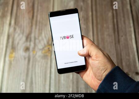 Ein Mobiltelefon oder Mobiltelefon, das in einem gehalten wird Hand mit der IVROSE App geöffnet auf dem Bildschirm Stockfoto