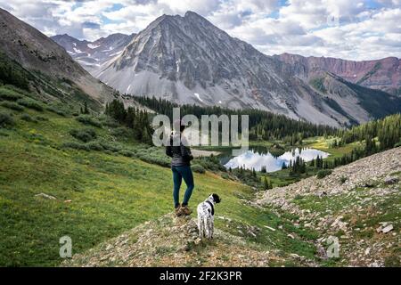Hikerin mit Hund und Blick auf den schönen Berg Stockfoto