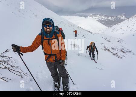 Menschen mit Skistöcken Splitboarding auf schneebedeckten Berg während des Urlaubs Stockfoto