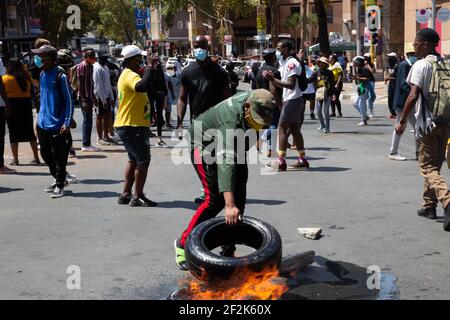 Johannesburg, Südafrika. März 2021, 12th. Ein Protestierender zündet während der Demonstration einen Autoreifen an.Studenten protestieren gegen die Weigerung der Wits University, Studenten mit Rückständen von Studiengebühren anzumelden. (Foto: Thabo Jaiyesimi/SOPA Images/Sipa USA) Quelle: SIPA USA/Alamy Live News Stockfoto