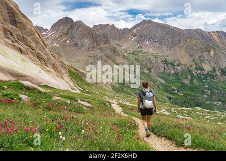 Rückansicht einer Frau, die im Urlaub auf den Bergen wanderte Stockfoto