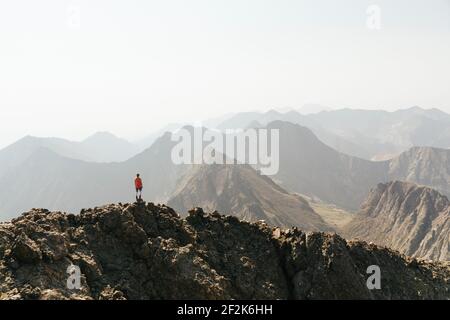 Frau mit Blick auf die Aussicht, während sie auf dem Gipfel des Berges steht Gegen klaren Himmel Stockfoto