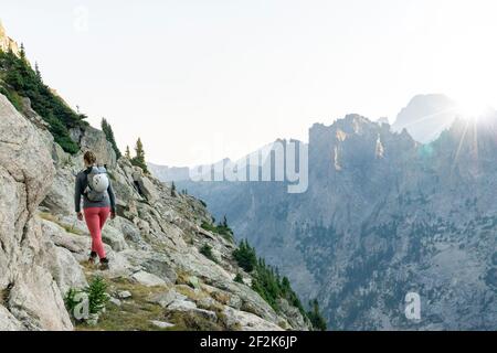 Rückansicht einer Frau, die auf dem Berg gegen den klaren Himmel wandert Während der Ferien Stockfoto