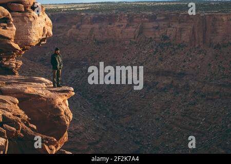 Mann, der am Rand der felsigen Klippe bei Canyonlands National steht Parken Stockfoto