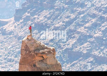 Mann auf dem Gipfel des felsigen Pinnacle im Canyonlands National Park Stockfoto