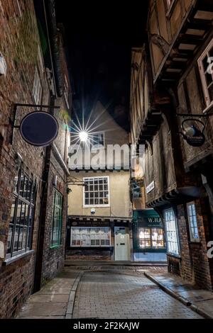 The Shambles in York, England, historische alte Kopfsteinpflasterstraße mit schiefen Gebäuden und Geschäften. Yorkshire, England. Kopfsteinpflasterstraßen Stockfoto