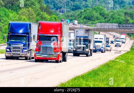 Horizontale Aufnahme einer verkehrsreichen Autobahn mit viel Verkehr und schillernden Sommerhitze. Stockfoto