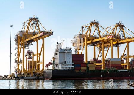 Weltweites Versand- und Frachtkonzept: Blick auf gelben Kranaufzug, der an einer Werft steht, um Container zu bewegen. Baumaschinen für die Logistik. Stockfoto