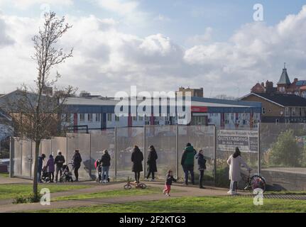 Eltern im Einklang mit der sozialen Distanzierung, um ihre Kinder zu pflücken Von einer Grundschule, die diese Woche nach drei wieder eröffnet Monate der Schließung aufgrund von Lockdown Covid-19/Coronavirus Pandemien Einschränkungen in London, England, Großbritannien Stockfoto