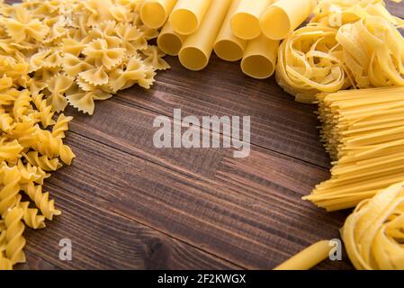 Verschiedene Arten von Pasta auf einem hölzernen Hintergrund. Stockfoto