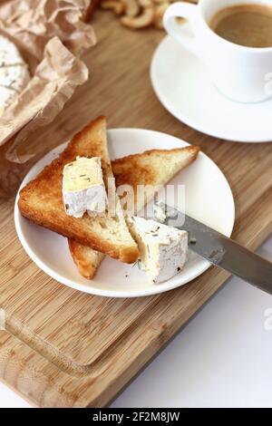 Frühstückstisch mit frischem Käse Toast, Kaffee, Nüsse auf Holzbrett. Stockfoto