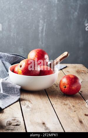 Frische rote Blutorangen in einer Schüssel auf einem Holztisch. Stockfoto