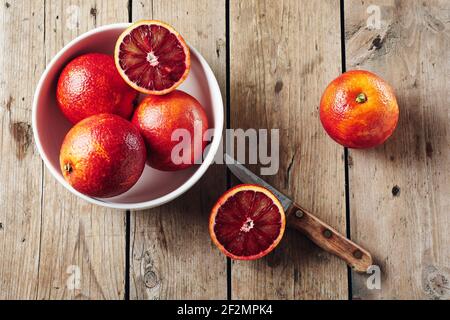 Frische rote Blutorangen in einer Schüssel auf einem Holztisch. Stockfoto