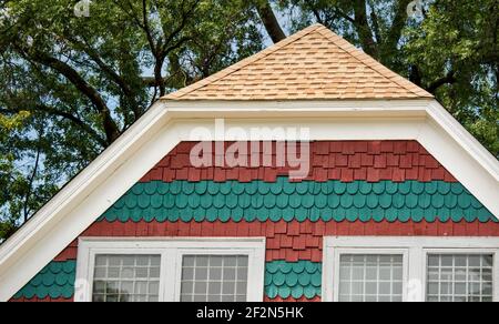 Historisches polychromes dekoratives Schindelmuster in einem New England Haus zeigt Reihen von auffälligen gemusterten Schindeln. Stockfoto