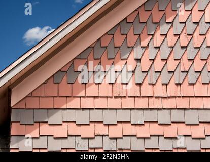 Historisches polychromes dekoratives Schindelmuster in einem New England Haus zeigt Reihen von auffälligen gemusterten Schindeln. Stockfoto