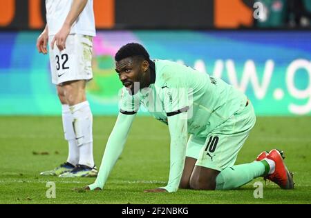 Augsburg, Deutschland. März 2021, 12th. Fußball: Bundesliga, FC Augsburg - Borussia Mönchengladbach, Matchday 25 in der WWK Arena. Mönchengladbachs Marcus Thuram kniet auf dem Rasen, nachdem er verschmutzt wurde. WICHTIGER HINWEIS: Gemäß den Bestimmungen der DFL Deutsche Fußball Liga und des DFB Deutscher Fußball-Bund ist es untersagt, im Stadion und/oder des Spiels aufgenommene Fotos in Form von Sequenzbildern und/oder videoähnlichen Fotoserien zu verwenden oder zu verwenden. Quelle: Matthias Balk/dpa/Alamy Live News Stockfoto