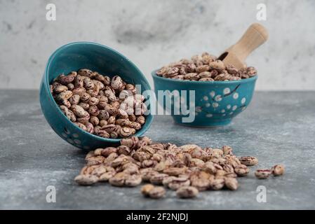 Rohe Bohnenkörner in Schalen auf Marmoroberfläche angezeigt Stockfoto