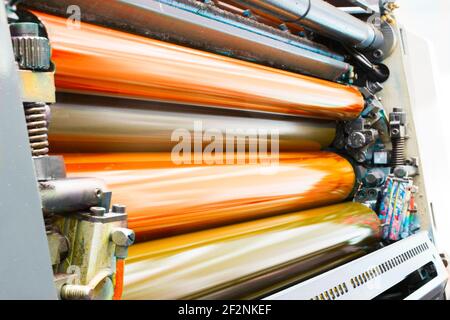 Color and glossy rollers of offset printing machine. offset ink colour. Orange Stock Photo