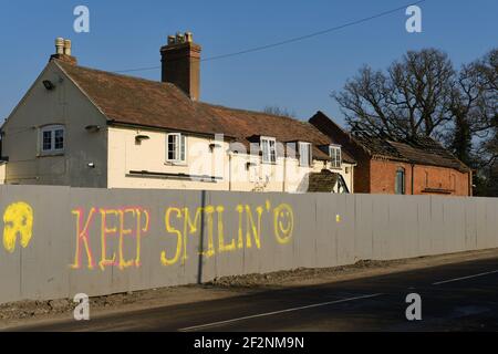 "Keep Smiling"-Graffiti auf einer Baustelle in Großbritannien Stockfoto
