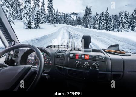 Verschneite Bergstraße aus dem Taxi eines LKW, Nutzfahrzeug gesehen. Dolomiten, Belluno, Venetien, Italien Stockfoto