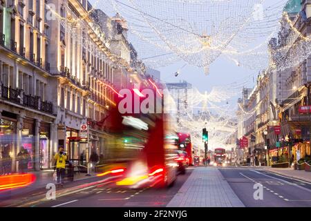 Der Londoner Bus fährt an der Regent Street vorbei, die bei Nacht mit Weihnachtslichtern geschmückt ist, London, Großbritannien Stockfoto