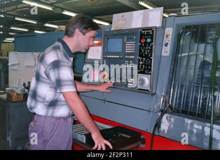 Ein Mann betreibt eine numerische Steuermaschine in einer Fabrik, Archivfoto, 90s. Tschechische republik. Stockfoto