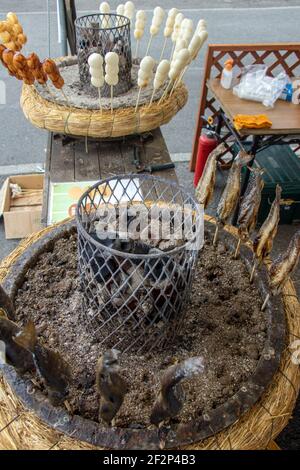 Gebratener Fisch auf einem Sticks um Heizung Kohle. Vertrieb von frisch gebackenen Fisch auf der Straße in Japan. Stockfoto