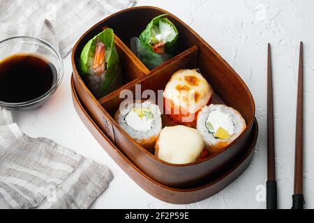 Hausgemachte Sushi Bento Box mit Sushi Rolls Set, auf weißem Stein Hintergrund Stockfoto