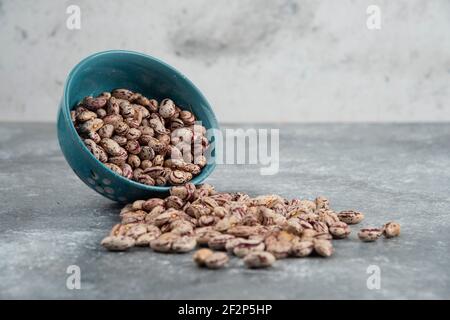 Rohe Bohnenkörner in Schalen auf Marmoroberfläche angezeigt Stockfoto