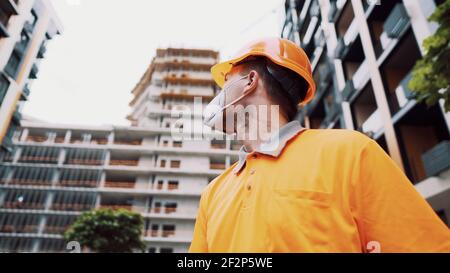 Bauarbeiter tragen Sicherheitsausrüstung. KN 95 Maske. Corona-Maske. Covid-19 Schutzmaske. Ausbruch des Coronavirus. Builder funktioniert in Stockfoto