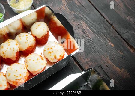 Vielfalt an verschiedenen Sushi und Rollen, Lachs und Thunfisch in Lieferung Food-Konzept-Set, auf alten dunklen Holztisch Hintergrund, mit Copyspace und Platz Stockfoto