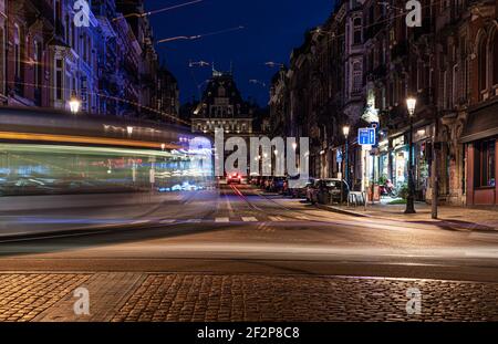 Saint-Gilles, Brüssel Hauptstadt Region - Belgien: 02 26 2021: Straßenbahn vorbei am Kreisverkehr Barriere bei Nacht Stockfoto