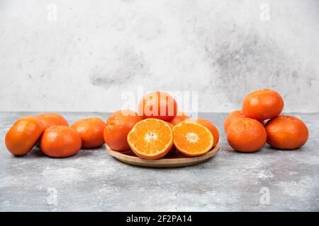 Saftige orange Früchte mit Scheiben auf Stein Hintergrund Stockfoto