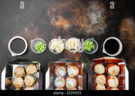 Vielfalt an verschiedenen Sushi und Rollen fro, Lachs und Thunfisch in Lieferung Food-Konzept-Set, auf alten dunklen rustikalen Hintergrund, mit Copyspace und Platz für t Stockfoto