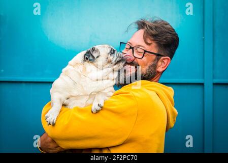 Mein bester Freund Hund Konzept mit lustigen Szene erwachsenen Mann Mit Bart und Mops Hund küssen ihn auf dem Gesicht - Menschen und Tiere haben Spaß und Liebe zusammen in Freundschaft Stockfoto