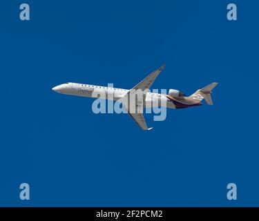 London, Heathrow Airport - August, 2019: Libyan Airlines, Bombardier CRJ-900, von Grund auf in einen strahlend blauen Himmel gesehen, Richtung Tripoli, L Stockfoto