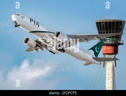 London, Heathrow Airport - April, 2019: Pakistan International Airline (PIA) mit einziehendem Fahrwerk in einen hellen Himmel mit dem Turm abheben Stockfoto